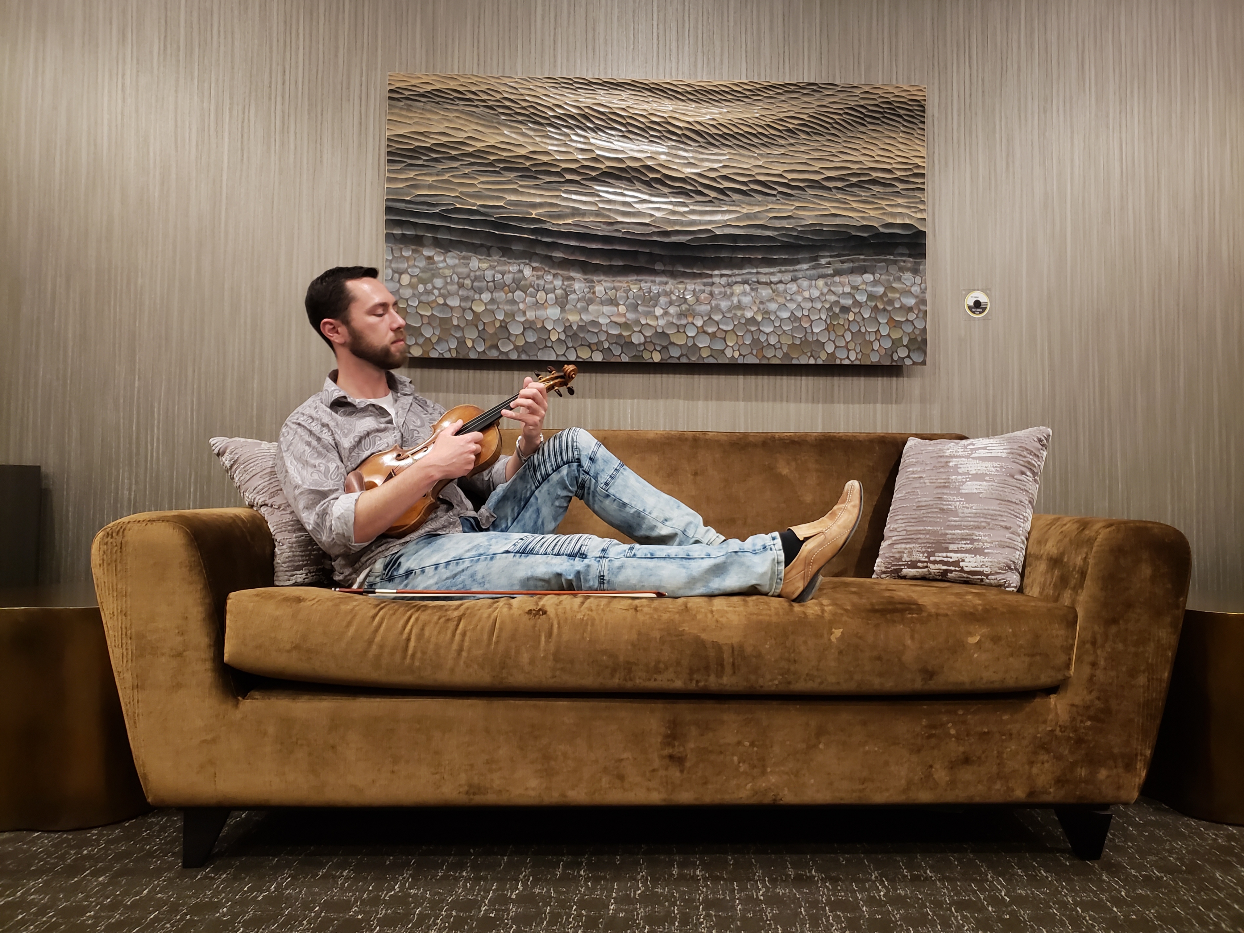 William Samorey seated with violin in a lounge setting
